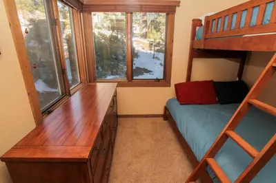a bedroom with a bunk bed and a desk and a window at Mountainback 73 Den in Mammoth Lakes
