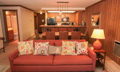 a living room with a red couch with pillows at Mountainback 73 Den in Mammoth Lakes