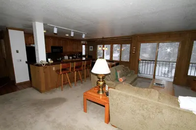 a living room with a couch and a table with a lamp at Mountainback 72 Corner Unit in Mammoth Lakes