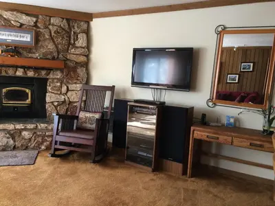 a living room with a tv and a stone wall at Mountainback #71 in Mammoth Lakes