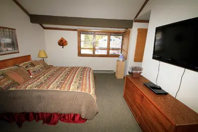 a bedroom with a bed and a flat screen tv at Mountainback 63 Loft Den in Mammoth Lakes