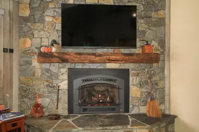 a stone fireplace with a television on top of it at Mountainback 12 2 Bdrm 3 Ba Loft - Pet Ok in Mammoth Lakes