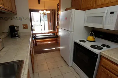 a kitchen with a white refrigerator and a stove at Discovery 4 #128, Loft in Mammoth Lakes
