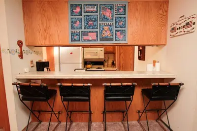 a kitchen with a counter with four bar stools at Discovery 4 #128, Loft in Mammoth Lakes