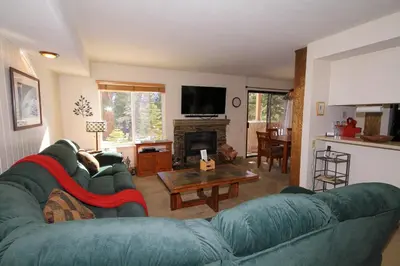 a living room with a blue couch and a table at Discovery 4 115 in Mammoth Lakes