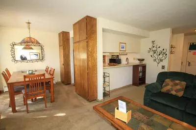 a living room with a table and a green couch at Discovery 4 115 in Mammoth Lakes