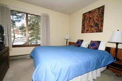 a bedroom with a blue bed and a window at Discovery 4 133 in Mammoth Lakes