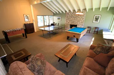 a living room with a ping pong table and a room with a fireplace at Discovery 4 133 in Mammoth Lakes