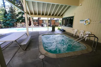 a hot tub in a patio with a table and chairs at Discovery 4 133 in Mammoth Lakes