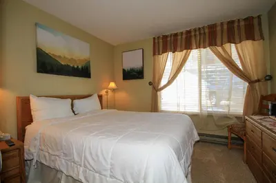 a bedroom with a white bed and a window at Discovery 4 137 in Mammoth Lakes