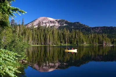 two people in a boat on a lake with a mountain at Horizons 4 140 1 Bedroom Loft 1 Bath in Mammoth Lakes