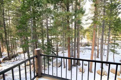 a balcony with a snow covered forest with trees at Forest Creek 3 Pet accepted in Mammoth Lakes