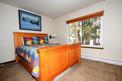 a bedroom with a wooden bed and a window at Discovery 4 152 Loft Pet Ok in Mammoth Lakes
