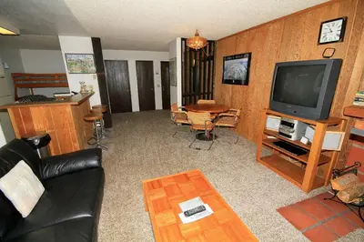 a living room with a couch and a tv and a table at Crestview 17 in Mammoth Lakes