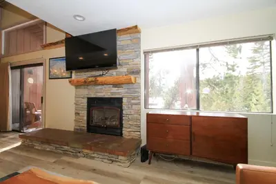 a living room with a fireplace and a flat screen tv at Mammoth Ski Racquet Club 86 - Pet Friendly in Mammoth Lakes