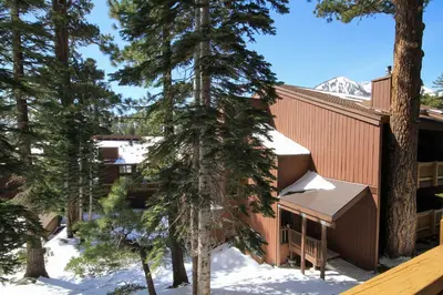 a building in the snow with trees at Mammoth Ski Racquet Club 94 2 bedroom Dog Friendly in Mammoth Lakes