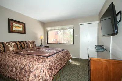 a hotel room with a bed and a flat screen tv at Mammoth Ski Racquet Club 94 2 bedroom Dog Friendly in Mammoth Lakes