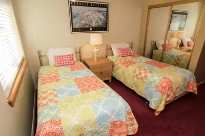a small bedroom with two beds and a mirror at Silver Bear #40 in Mammoth Lakes