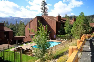 a building with a swimming pool in front of it at Mammoth Ski Racquet Club 129 in Mammoth Lakes