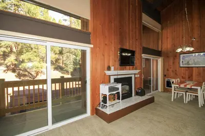 a screened in porch with a fireplace and a dining room at Mammoth Ski Racquet Club 120 - Pet Friendly in Mammoth Lakes