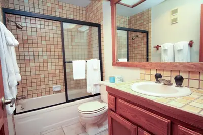 a bathroom with a sink and a toilet and a mirror at Mountainback 115 3 bedroom loft in Mammoth Lakes