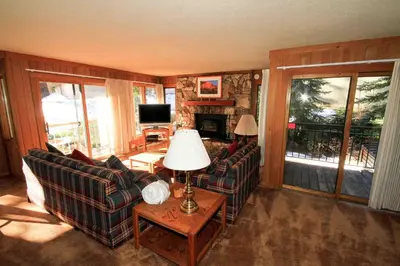 a living room with two couches and a table with a lamp at Mountainback 112 Corner Unit in Mammoth Lakes
