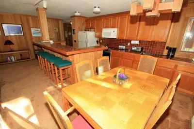 an empty kitchen with a wooden table and chairs at Mountainback 112 Corner Unit in Mammoth Lakes