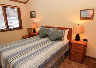 a bedroom with a bed with two night stands and two lamps at Mountainback 105 Loft Den in Mammoth Lakes