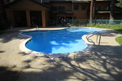 a large blue swimming pool in front of a house at Mountainback 97 Loft in Mammoth Lakes