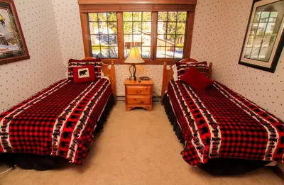 a bedroom with two beds and a table with a lamp at Mountainback 94 in Mammoth Lakes