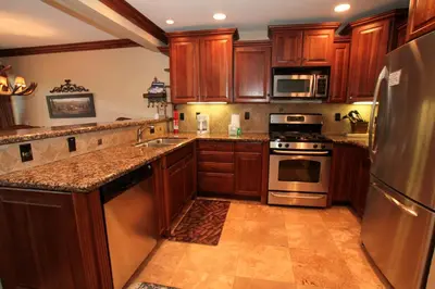 a kitchen with wooden cabinets and stainless steel appliances at Mammoth Ski Racquet Club 34 in Mammoth Lakes