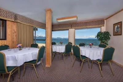 a restaurant with tables and chairs and a view of the ocean at Tahoe Lakeshore Lodge & Spa in South Lake Tahoe