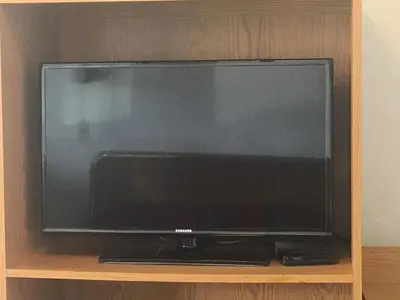 a flat screen tv sitting on a wooden shelf at San Joaquin Motel in Merced