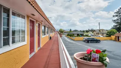 a balcony of a building with flowers in a pot at Hollister Inn in Hollister