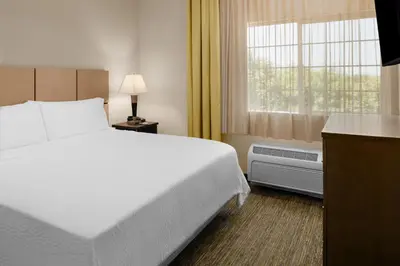 a hotel room with a bed and a window at Candlewood Suites Turlock by IHG in Turlock