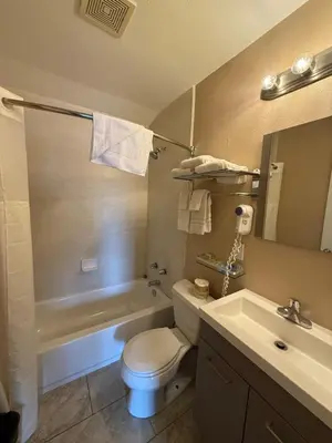 a bathroom with a toilet and a tub and a sink at Beverly Lodge in South Lake Tahoe