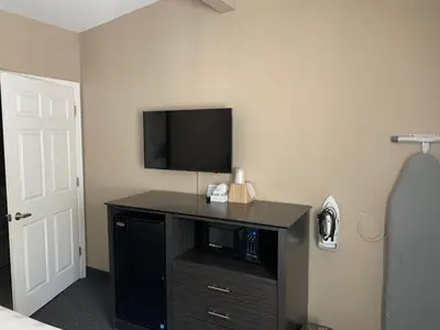 a bedroom with a tv on a desk with a microwave at Black Jack Inn in South Lake Tahoe