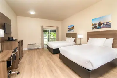 a hotel room with two beds and a television at Westhaven Inn Pollock Pines Camino in Pollock Pines