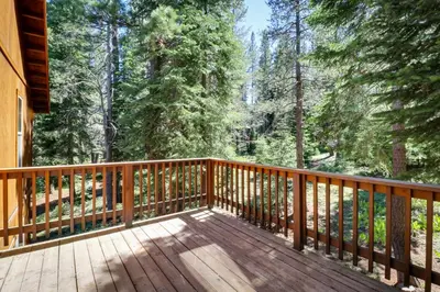 a wooden deck with trees in the background at Wooded Escape in Donner Pines Tract