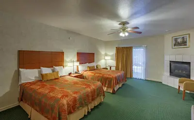 a hotel room with two beds and a ceiling fan at Miners Inn in Mariposa