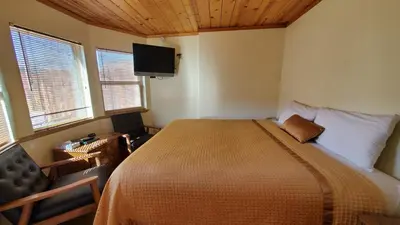 a bedroom with a bed and a flat screen tv at Kernville Inn in Kernville