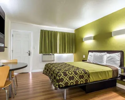 a small room with a bed and a table at Rodeway Inn Downtown Hanford in Hanford