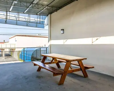 a wooden picnic table sitting on the side of a building at Rodeway Inn Downtown Hanford in Hanford