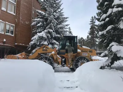 a bulldozer in the snow in front of a house at Mountainback 62 in Mammoth Lakes