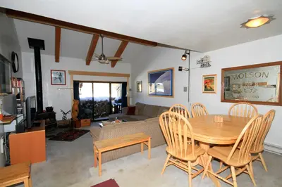 a living room with a wooden table and chairs at Courchevel 51 in Mammoth Lakes