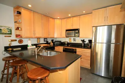 a kitchen with wooden cabinets and a stainless steel refrigerator at Courchevel 51 in Mammoth Lakes