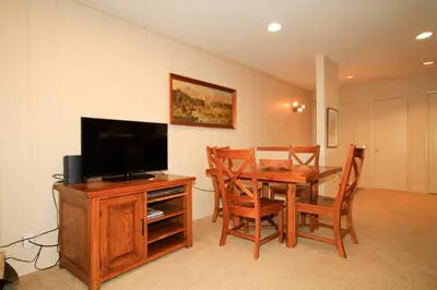 a dining room with a television and a table with chairs at Crestview 63 in Mammoth Lakes