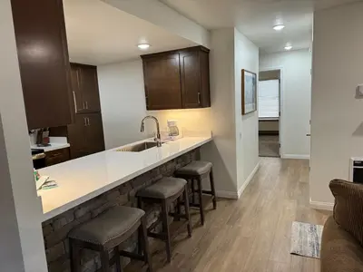 a kitchen with a sink and stools in a room at Horizons 4 169 2 Bedroom 2 Bath in Mammoth Lakes