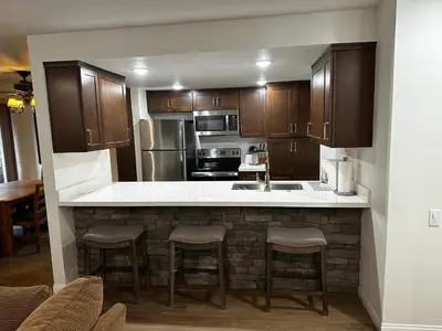 a kitchen with wooden cabinets and a counter with bar stools at Horizons 4 169 2 Bedroom 2 Bath in Mammoth Lakes