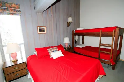 a bedroom with two beds with red sheets at Mammoth Ski Racquet Club 74 1 Bdrm Loft in Mammoth Lakes